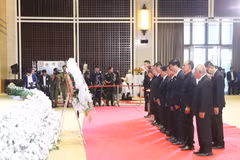 Representatives of the General Association of Vietnamese People in Laos and the Association of Vietnamese People in Vientiane lay a wreath and observe a minute of silence in memory of Lao National Assembly President Xaysomphone Phomvihane. (Photo: VNA) 