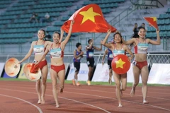 Hoang Thi Minh Hanh, Nguyen Thi Hang, Le Thi Tuyet Mai, and Nguyen Thi Ngoc celebrate their gold medal in the women’s 4x400m relay on December 16. (Photo: VNA)
