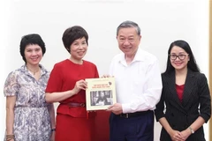 General Director of the Vietnam News Agency (VNA) Vu Viet Trang (second from left) presents the photo book to Party General Secretary To Lam. (Photo: VNA)