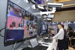 Visitors at an exhibition showcasing technology devices for cybersecurity. (Photo: VNA) 