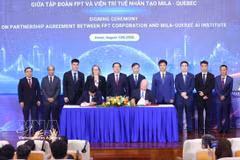 Deputy Prime Minister Ho Quoc Dung (fifth from left) and delegates witness the signing of the strategic cooperation agreement for the next phase between FPT Corporation and Mila – Quebec AI Institute of Canada. (Photo: VNA)