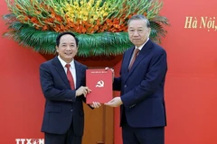 General Secretary of the Communist Party of Vietnam Central Committee To Lam (R) presents the Politburo's decision to General Trinh Van Quyet. (Photo: VNA)
