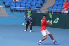 Vu Ha Minh Duc returns a ball to Maximus Jones of Thailand during their singles match at the Davis Cup Asia/Oceania Group III 2025 Pool A on July 14 in Bac Ninh province. (Photo: VTF)