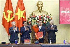 Prime Minister Pham Minh Chinh (second from left) and National Assembly Chairman Tran Thanh Man (far right) present the appointment decision and offer flowers to Nguyen Hong Dien. (Photo: VNA) 