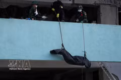 Rescuers retrieve the body of an earthquake victim from the rubble. (Photo: VNA)