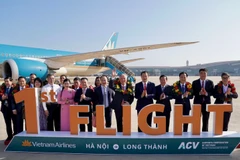 Vietnam Airlines's first passenger flight to Long Thanh carries Deputy Prime Minister Nguyen Hoa Binh (sixth from right) and nearly 100 passengers (Photo: VNA)