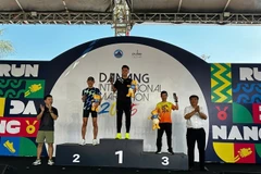 Huynh Anh Khoi (centre) takes the award for the men’s 42km division in the Da Nang International Marathon 2025. (Photo courtesy of Da Nang International Marathon 2025)