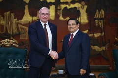 Prime Minister Pham Minh Chinh (R) welcomes TASS Director General Andrey Kondrashov (Photo: VNA)