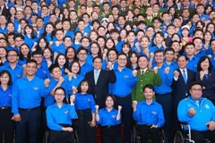 Prime Minister Pham Minh Chinh and officials pose for a group photo with young people at the dialogue on March 24. (Photo: VNA)