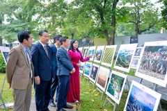 Visitors at the exhibition showcasing outstanding works of the 13th International Photo Contest in Vietnam (Photo: VNA)