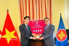 Vietnam’s Ambassador to Austria Vu Le Thai Hoang (R) presents Vietnamese coffee to an international student. (Photo: VNA)