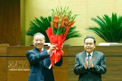 National Assembly Chairman Tran Thanh Man (R), on behalf of the Party and State leaders and deputies of the 16th National Assembly, presents flowers to congratulate Party General Secretary and State President To Lam. (Photo: VNA) 