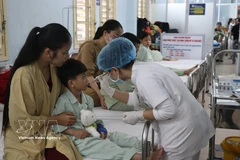 A health worker examines the surgical wound of a patient after surgery. (Photo: VNA) 