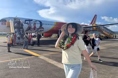 A passenger poses for a photo besides a Vietjet aircraft (Photo: VNA)