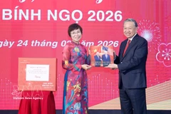 VNA General Director Vu Viet Trang (L) presents a photo book to Party General Secretary To Lam. (Photo: VNA)
