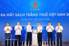 Minister of Finance Ngo Van Tuan (third from left) presents the White Book on Vietnam Taxation 2026 to Director the Tax Department Mai Xuan Thanh at the launch in Hanoi on May 12. (Photo: VNA) 