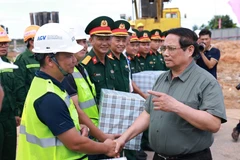 Prime Minister Pham Minh Chinh (R) meets with the units constructing Terminal 2 of Dong Hoi Airport (Photo: VNA)