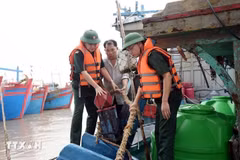 Military officers assist fishermen in Hai Thinh commune, Ninh Binh province, to gear up for the storm. (Photo: VNA)