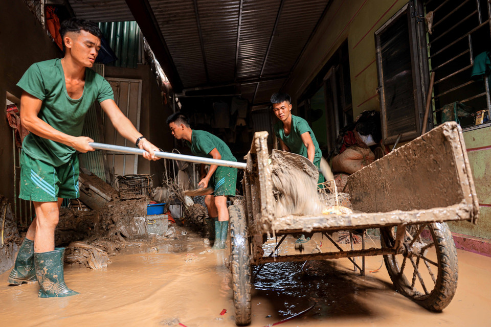 Soldiers from Division 316 assist residents of Phuc Khanh commune, Bao Yen district in Lao Cai province in cleaning up homes after the floods. (Photo: Hoang Hieu - VNA).