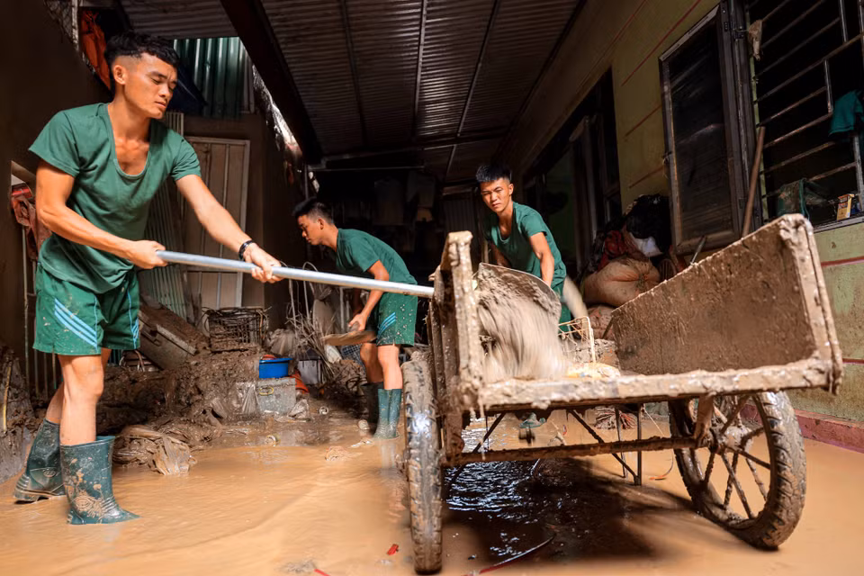 Soldiers from Division 316 assist residents of Phuc Khanh commune, Bao Yen district in Lao Cai province in cleaning up homes after the floods. (Photo: Hoang Hieu - VNA).