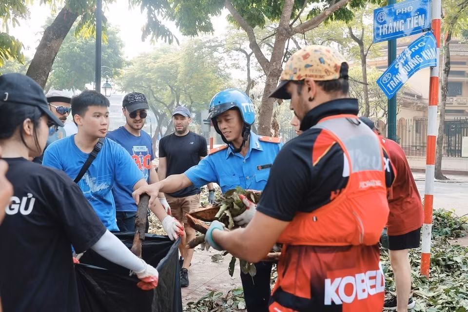 Foreigners join the clean up along Hoan Kiem district’s streets in Hanoi. (Photo: VNA)