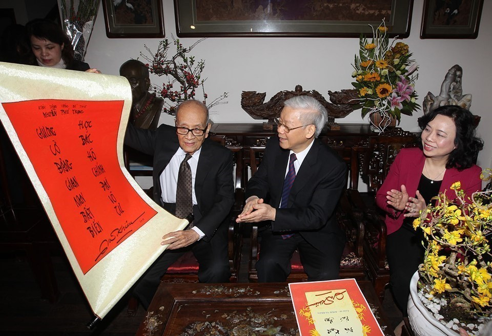 Professor Vu Khieu presents a pair of parallel sentences to Party General Secretary Nguyen Phu Trong while the latter visited his family on the occasion of traditional Lunar New Year (Tet holiday) (Hanoi, February 16, 2015). (Photo: Tri Dung – VNA)