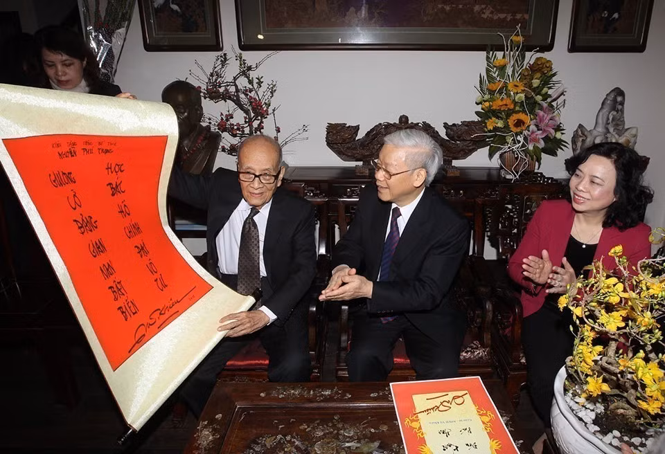 Professor Vu Khieu presents a pair of parallel sentences to Party General Secretary Nguyen Phu Trong while the latter visited his family on the occasion of traditional Lunar New Year (Tet holiday) (Hanoi, February 16, 2015). (Photo: Tri Dung – VNA)