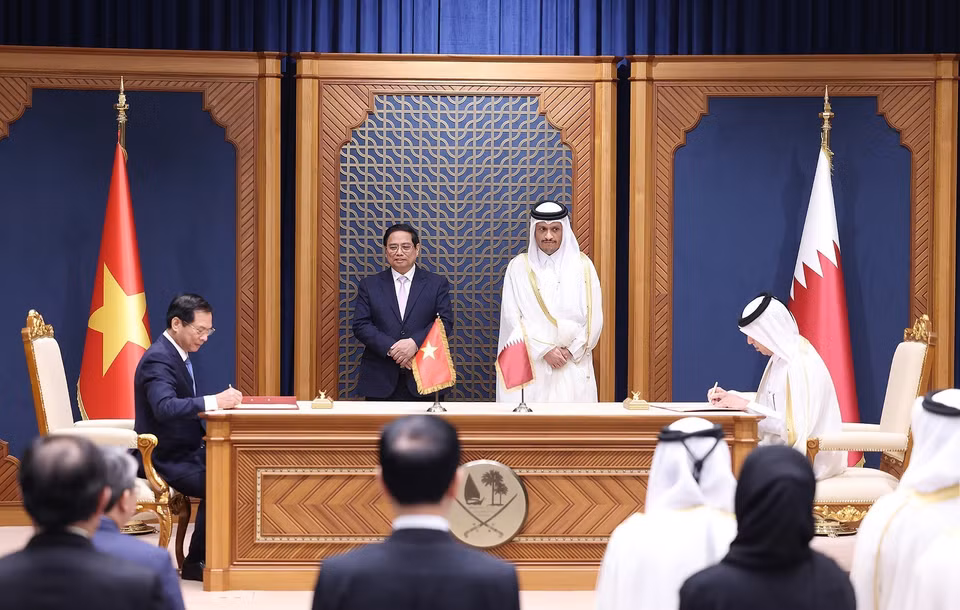 Prime Minister Pham Minh Chinh and Qatari Prime Minister Sheikh Mohammed bin Abdulrahman bin Jasim Al-Thani witness the signing of a protocol on air transportation between the governments of Vietnam and Qatar. (Photo: Duong Giang - VNA)