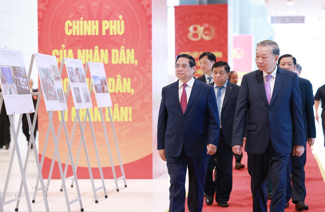 Party General Secretary To Lam (R) and PM Pham Minh Chinh, together with other delegates, visit a photo exhibition on the activities of the Government throughout history. (Photo: VNA)