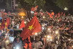 People take to Hanoi streets waving the national flag in celebration of the victory. (Photo: VNA)
