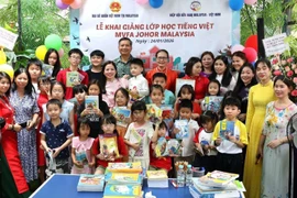 Ambassador Dinh Ngoc Linh and Chairwoman Tran Thi Chang with teachers and students of the Vietnamese-language class at the ceremony. (Photo: VNA)