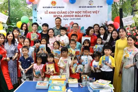 Ambassador Dinh Ngoc Linh and Chairwoman Tran Thi Chang with teachers and students of the Vietnamese-language class at the ceremony. (Photo: VNA)