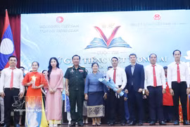 Representatives of the Vietnamese Embassy in Laos and the Lao Ministry of National Defence present the third prize to a winning team at the "Future Vietnamese Language Ambassadors" contest in Vientiane. (Photo: VNA) 