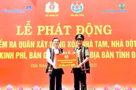 Lieutenant General Pham The Tung (R), member of the Party Central Public Security Committee and Deputy Minister of Public Security, presents the token for funding to eliminate 500 makeshift and dilapidated houses in Dak Nong province. (Photo: VNA) 