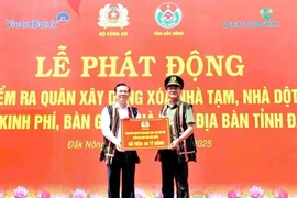 Lieutenant General Pham The Tung (R), member of the Party Central Public Security Committee and Deputy Minister of Public Security, presents the token for funding to eliminate 500 makeshift and dilapidated houses in Dak Nong province. (Photo: VNA) 