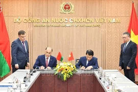 Vietnamese Minister of Public Security General Luong Tam Quang and State Secretary of the Security Council of Belarus Volfovich Aleksandr Grigorievich sign a protocol to establish a joint working group to expand and strengthen cooperation in security. (Photo: VNS)