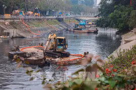 Vehicles and equipment are deployed to dredge a river in Hanoi. (Photo: VNA)