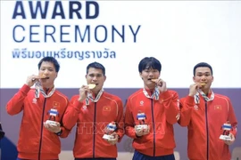 Fencing athletes Nguyen Xuan Loi, Nguyen Van Quyet, Le Van Bang, Phan Anh Duong dominate Malaysia 45–27 in the team final to win gold. (Photo: VNA)