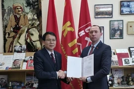 Sergei Syrankov, First Secretary of the Central Committee of the Communist Party of Belarus (right), presents a congratulatory letter to Vietnamese Ambassador to Belarus Nguyen Van Trung on the 14th National Party Congress. (Photo: VNA)