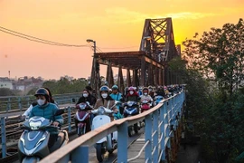 Motorcyclists cross the bridge. (Photo: VNA) 