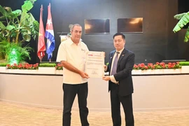 Cuba’s Minister of Agriculture Ydael Perez Brito (L) presents certificates of merit to a group of Vietnamese experts and engineers, along with the Vietnam Academy of Agricultural Sciences, in recognition of their significant contributions to Vietnam–Cuba rice production cooperation. (Photo: VNA) 