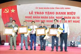 Leaders of the Ministry of Industry and Trade and the Bac Ninh Department of Industry and Trade present the title of Meritorious Artisan to outstanding individuals. (Photo: VNA) 