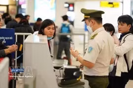 Passengers undergo security check at an airport. (Photo: VNA) 
