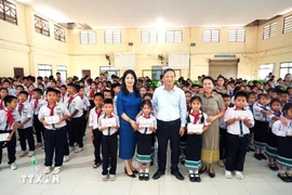Ambassador Nguyen Minh Tam and his spouse pose for a photo with representatives of the Lao–Vietnamese Nguyen Du Bilingual School and its students. (Photo: VNA) 