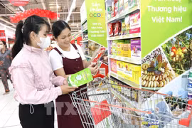 Consumers shop at a supermarket. (Illustrative photo: VNA)