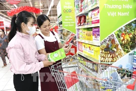 Consumers shop at a supermarket. (Illustrative photo: VNA)