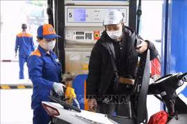 A motorcyclist has his vehicle refilled at a Petrolimex station. (Photo: VNA)