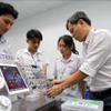 A lecturer from the faculty of electronic technology at the Ho Chi Minh City University of Industry provides guidance to students during a study and research session at the university's IoT and AI laboratory. (Photo: VNA)