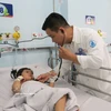 Dr Du Tuan Quy from the Children’s Hospital 1 in Ho Chi Minh City examines a patient with hand, foot and mouth disease. (Photo: VNA)
