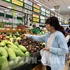 A consumer buys fruits at a supermarket in Ho Chi Minh City. (Photo: VNA)